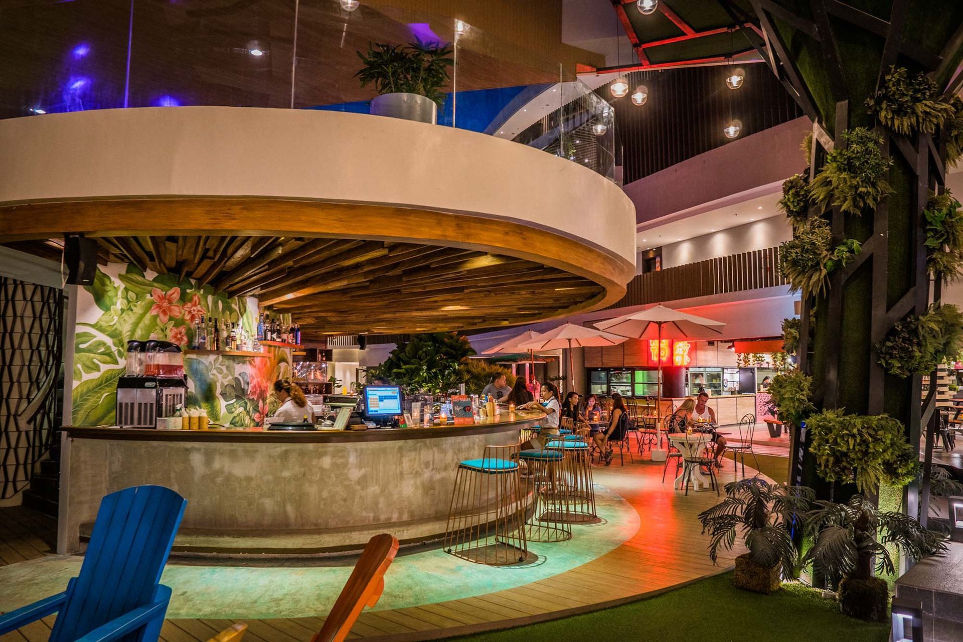 Evening ambiance at Hue Boracay's Food Hall with curved bar counter and tropical-themed dining space