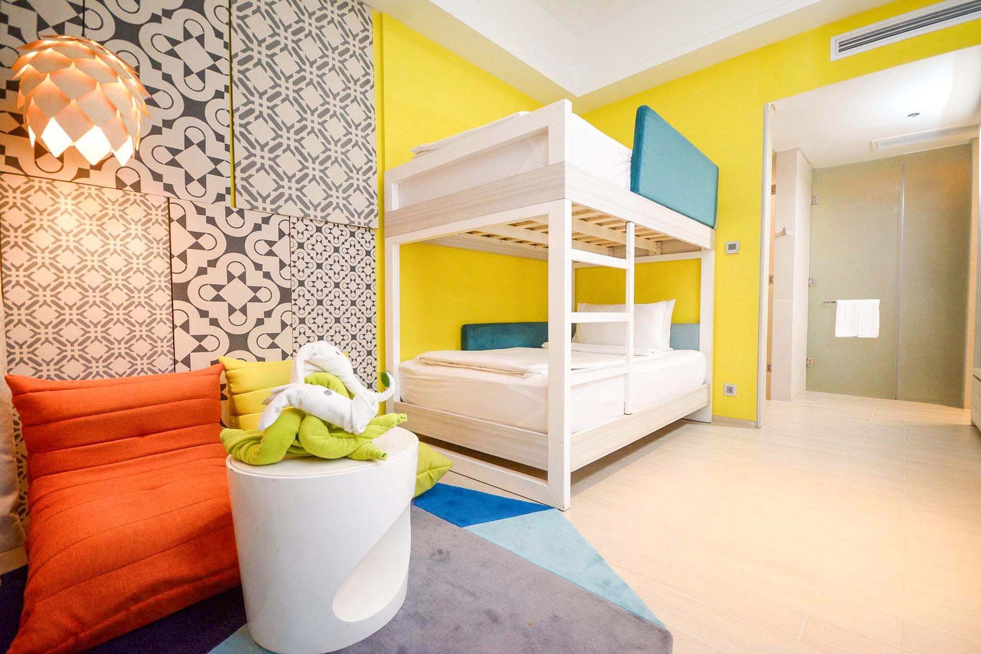 Modern bunk bed setup at Hue Hotel Puerto Princesa family room with vibrant yellow walls and decor