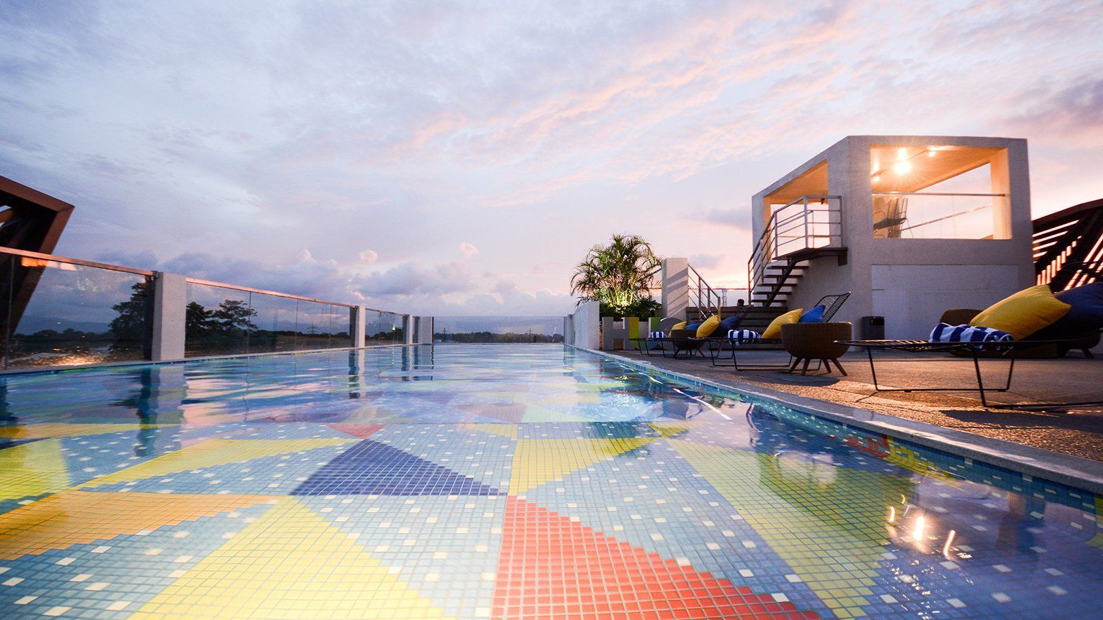 Rooftop infinity pool at best Puerto Princesa hotel with colorful mosaic tiles and sunset mountain views