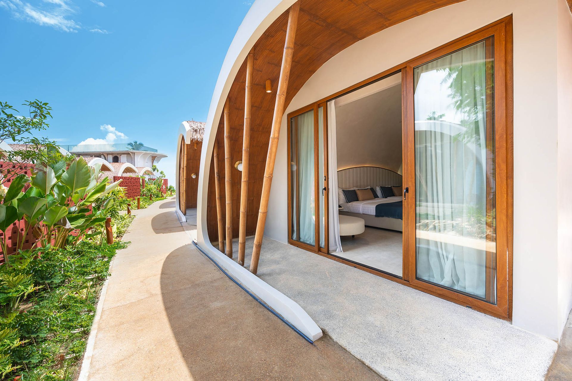 Tropical resort villa with bamboo arch entrance and sliding glass doors at 