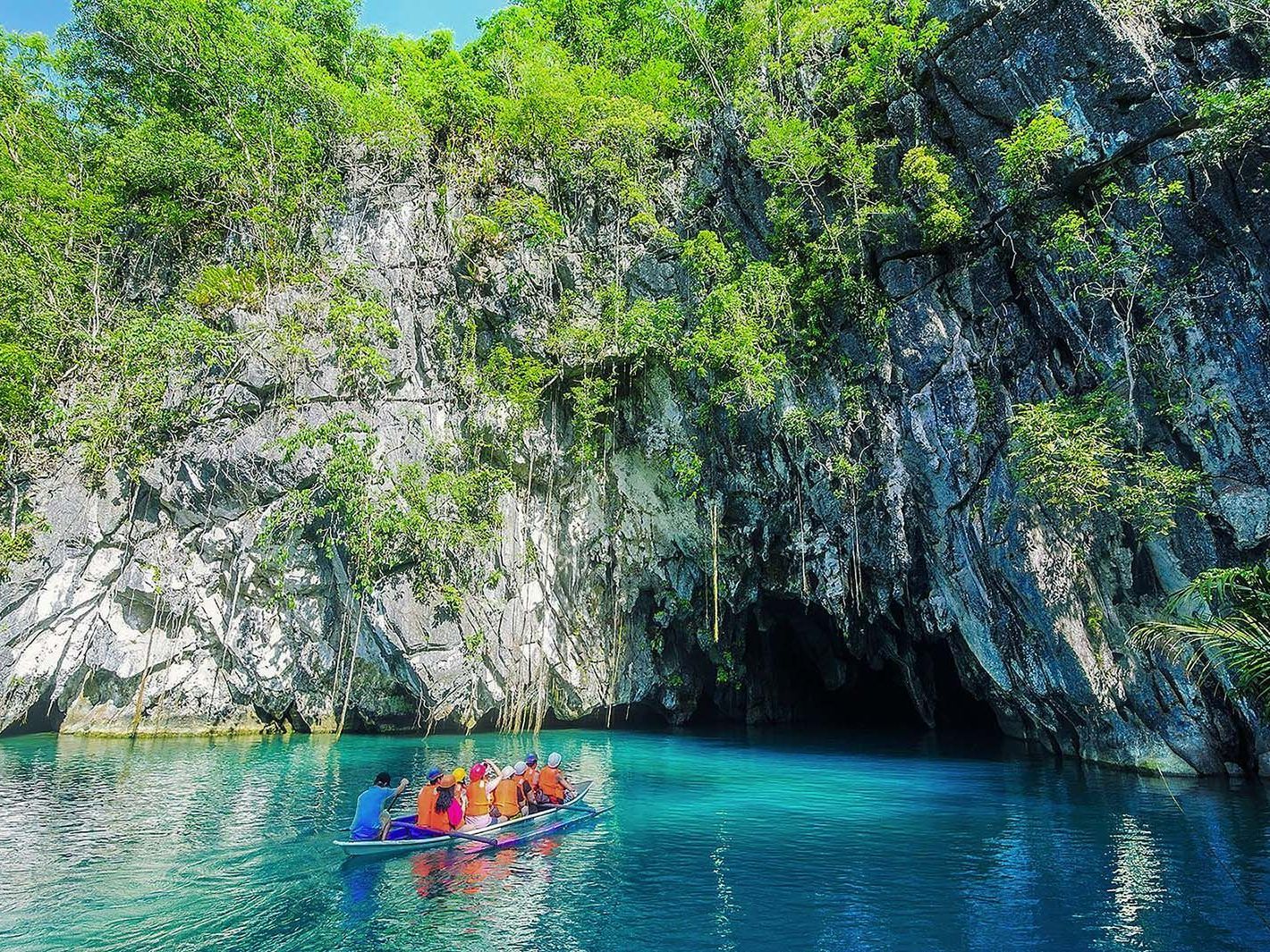 Tourists in life vests on a boat entering Puerto Princesa Underground River