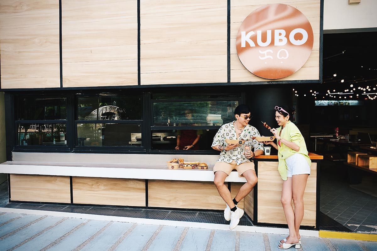 A man and a woman are standing in front of kubo restaurant in boracay