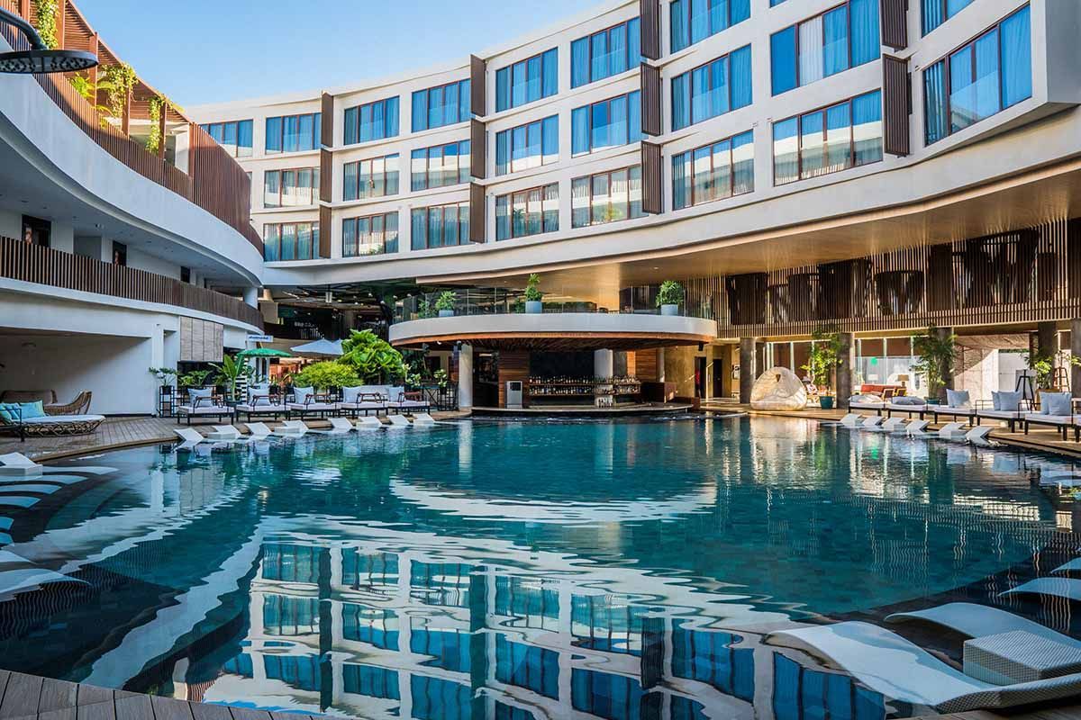 Modern curved pool surrounded by restaurants and lounging areas at Hue Boracay Station 2 family hotel