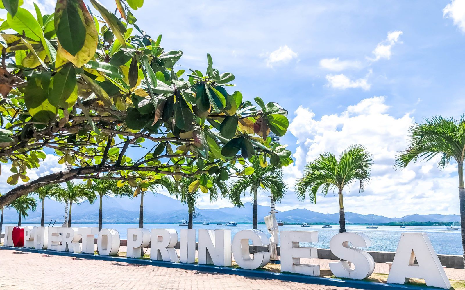 I Love Puerto Princesa waterfront sign with palm trees and bay views