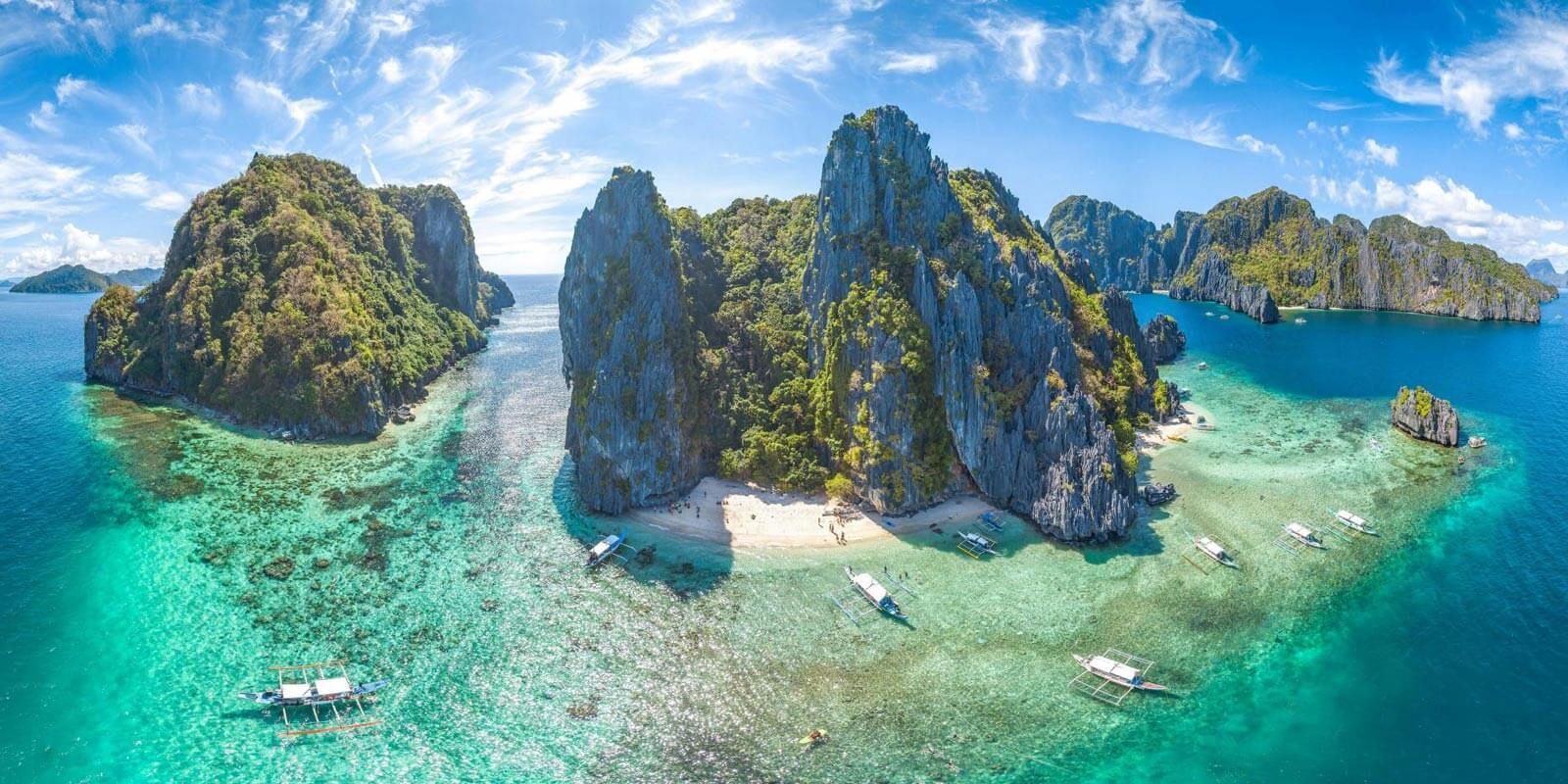 Tropical islands with turquoise water, a white sand beach, and blue sky.