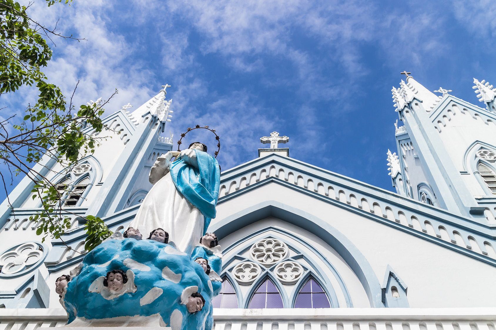 Virgin Mary statue outside blue-white Gothic Catholic church in Puerto Prin