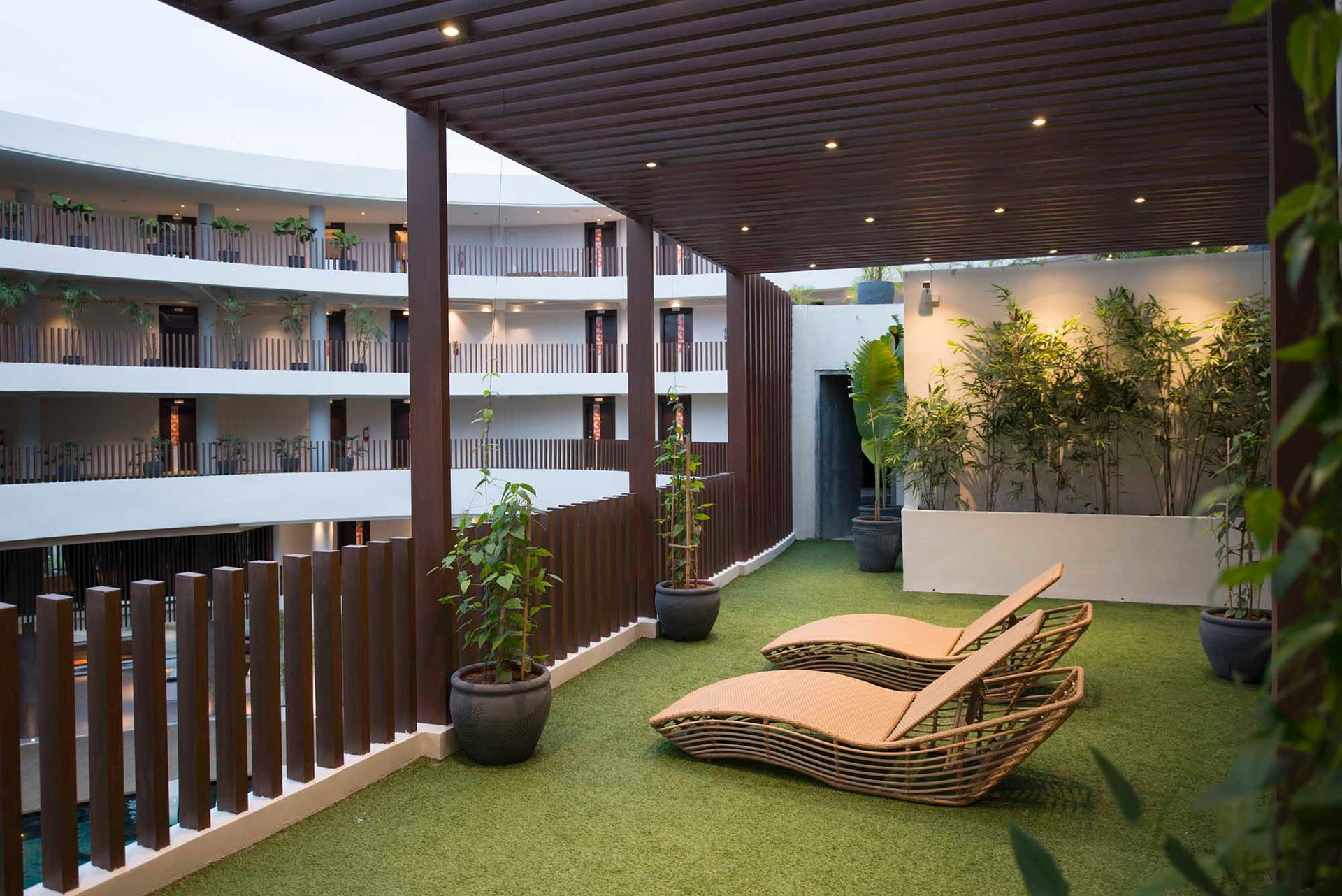 A balcony with two lounge chairs under a pergola