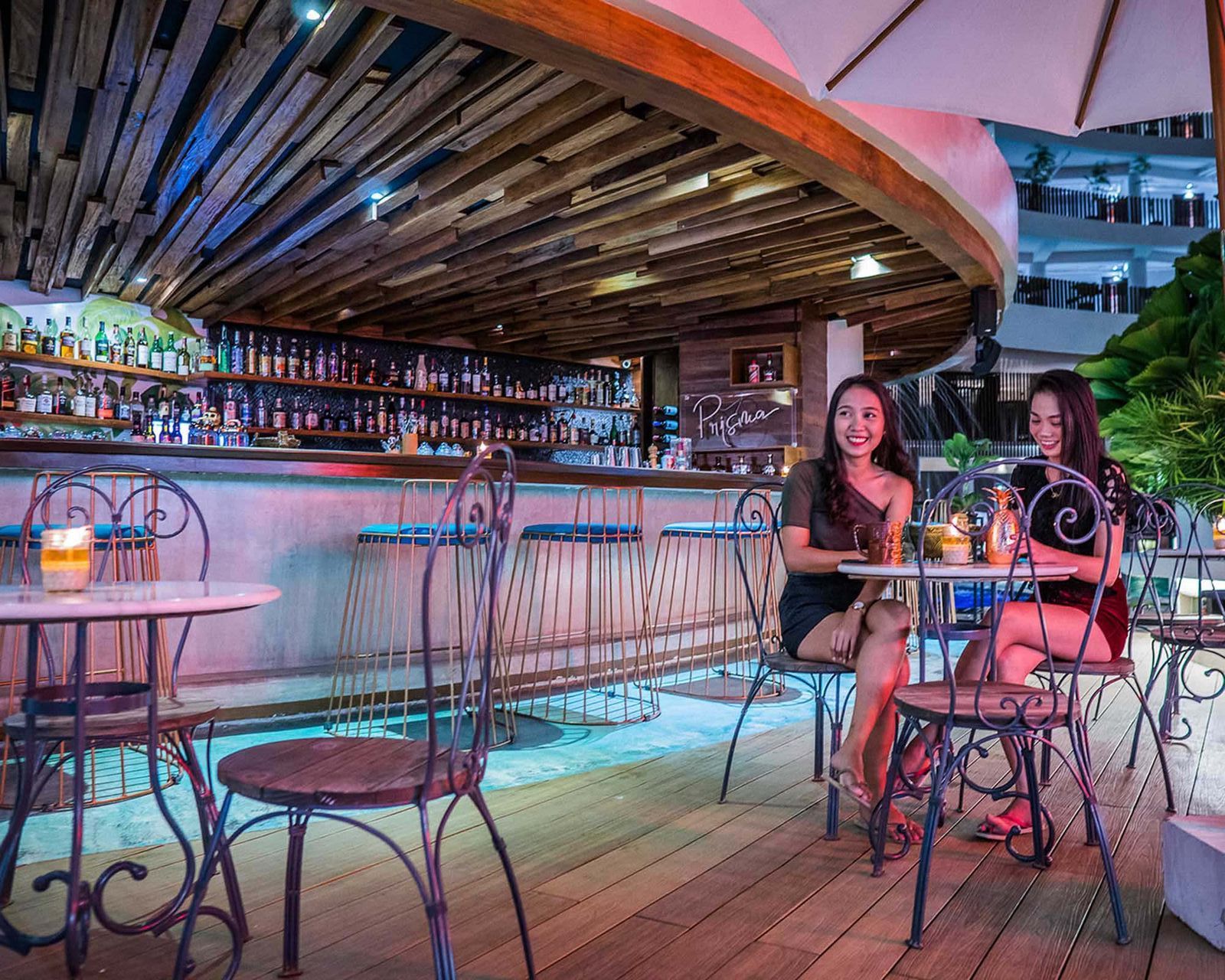 Two women enjoying cocktails at Prisma Pool Bar in Hue Hotel Boracay