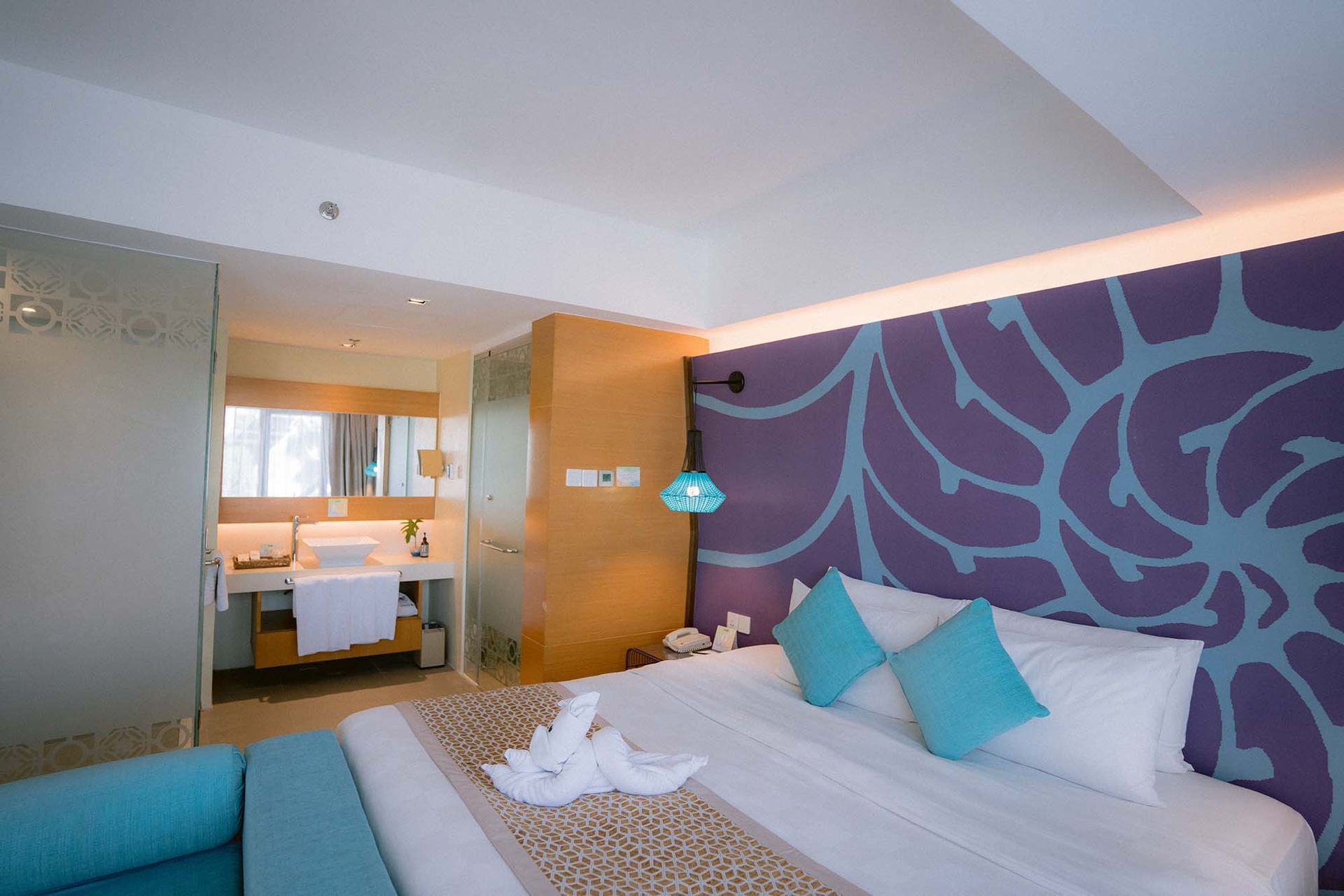 Stylish hotel room with purple floral wall and turquoise accents at Hue Hot