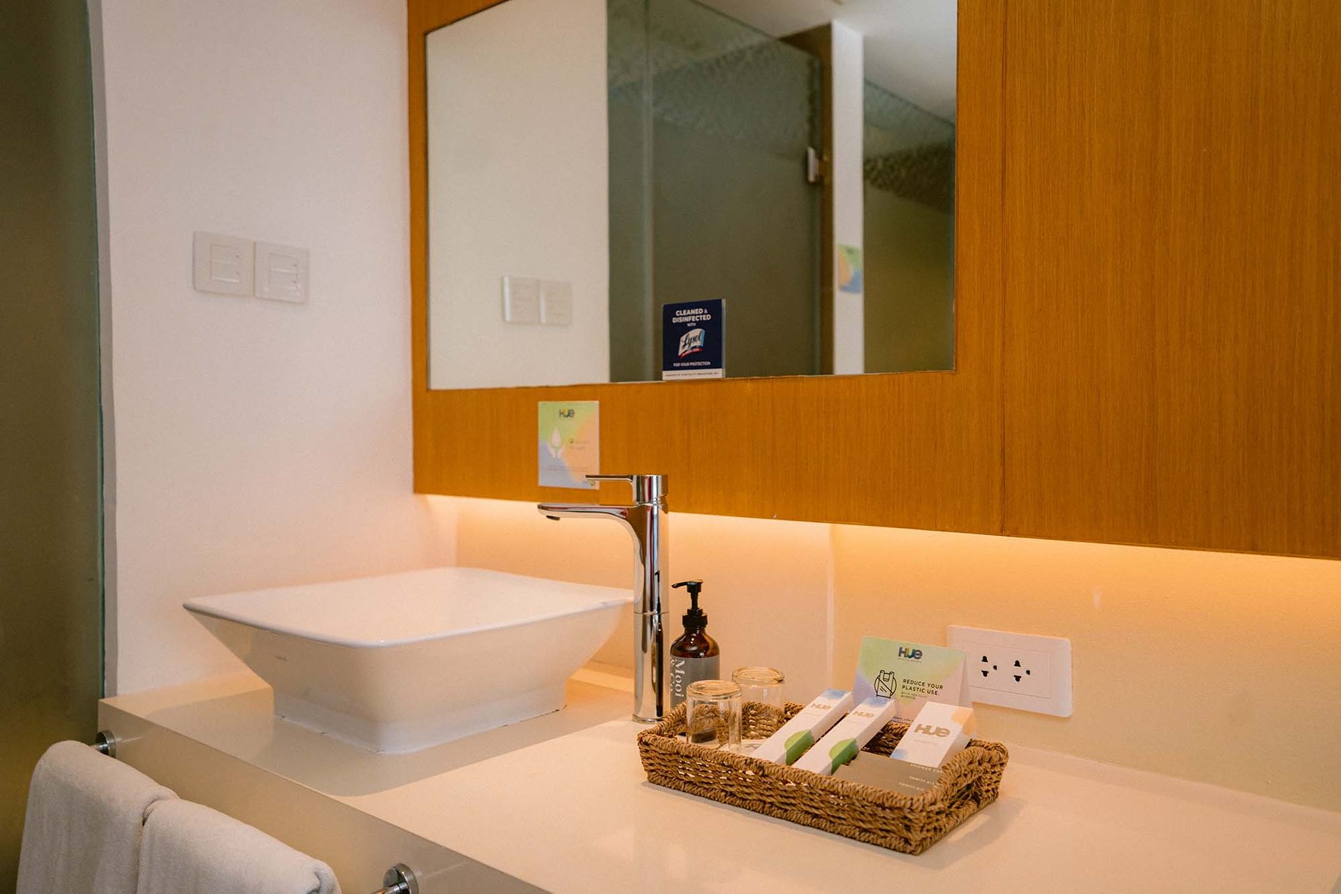 Modern bathroom vanity in Boracay suite featuring vessel sink, wooden accent wall, and complimentary toiletries