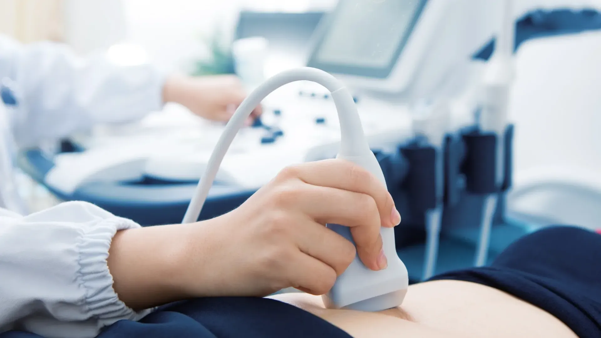 A woman is getting an ultrasound on her stomach.