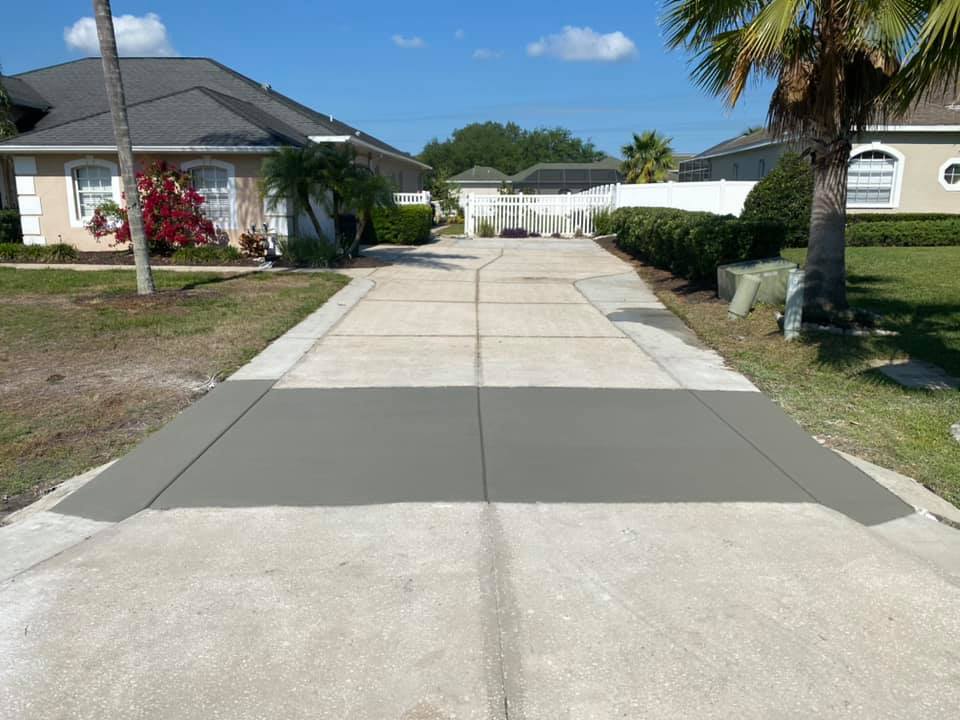 Newly poured concrete driveway with fresh gray sections; residential setting.