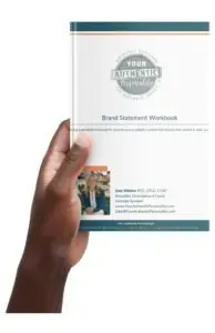 Hand holding a white workbook titled “Brand Statement Workbook” with teal accents