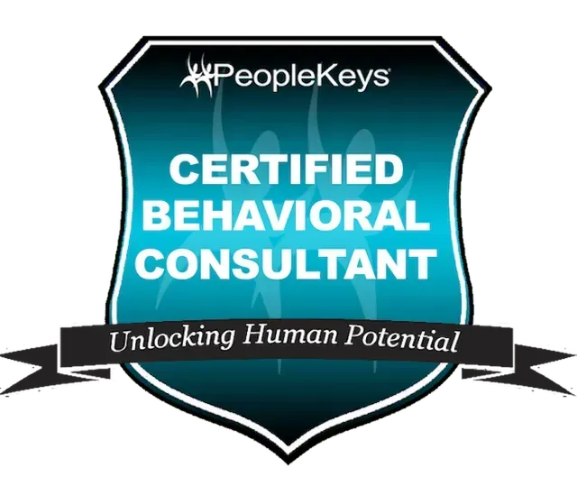 PeopleKeys Certified Behavioral Consultant badge with teal shield and black ribbon reading “Unlocking Human Potential”