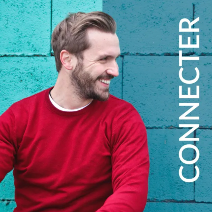 Smiling man in a red sweater against a turquoise wall with “CONNECTER” text