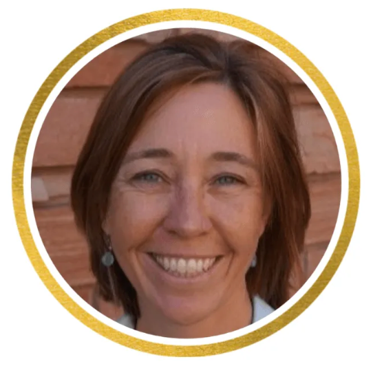 Smiling woman’s portrait in a circular frame with a gold border against a wooden background
