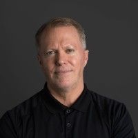 Portrait of a man in a black shirt against a dark gray background