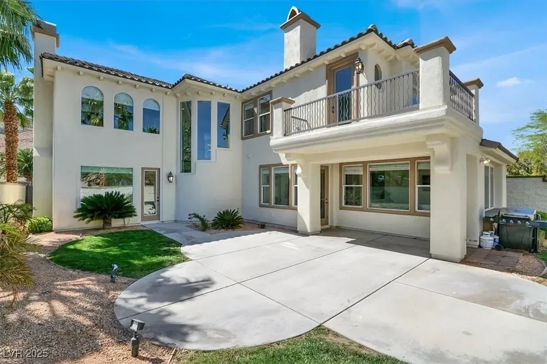 Modern two-story stucco house with a two-car garage and curved driveway