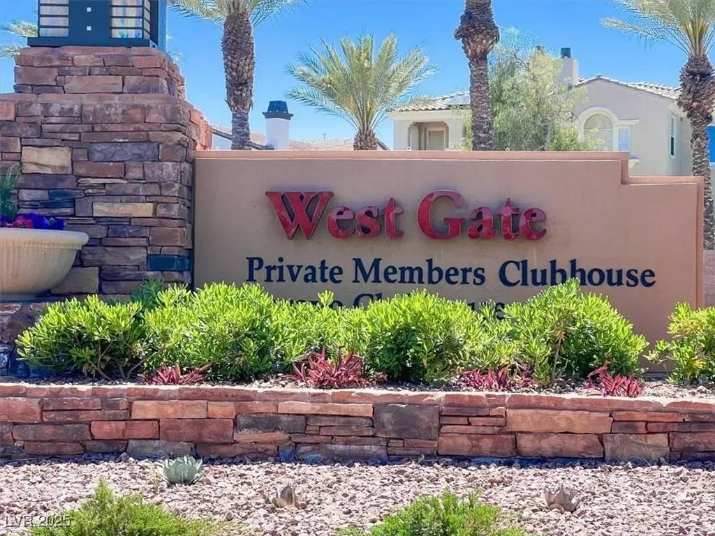 West Gate Private Members Clubhouse sign by stone landscaping and palm trees