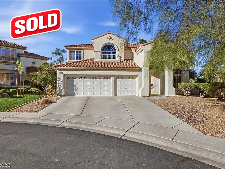 Sold sign over a beige suburban house with a three-car garage and driveway