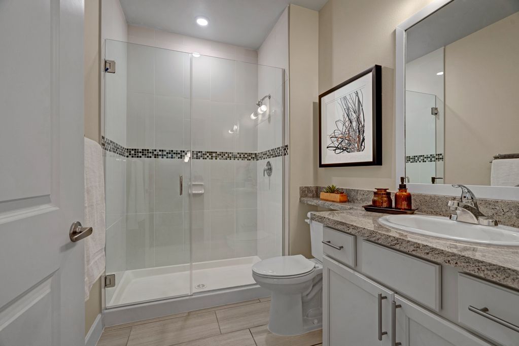 A bathroom with a toilet , sink , and walk in shower.