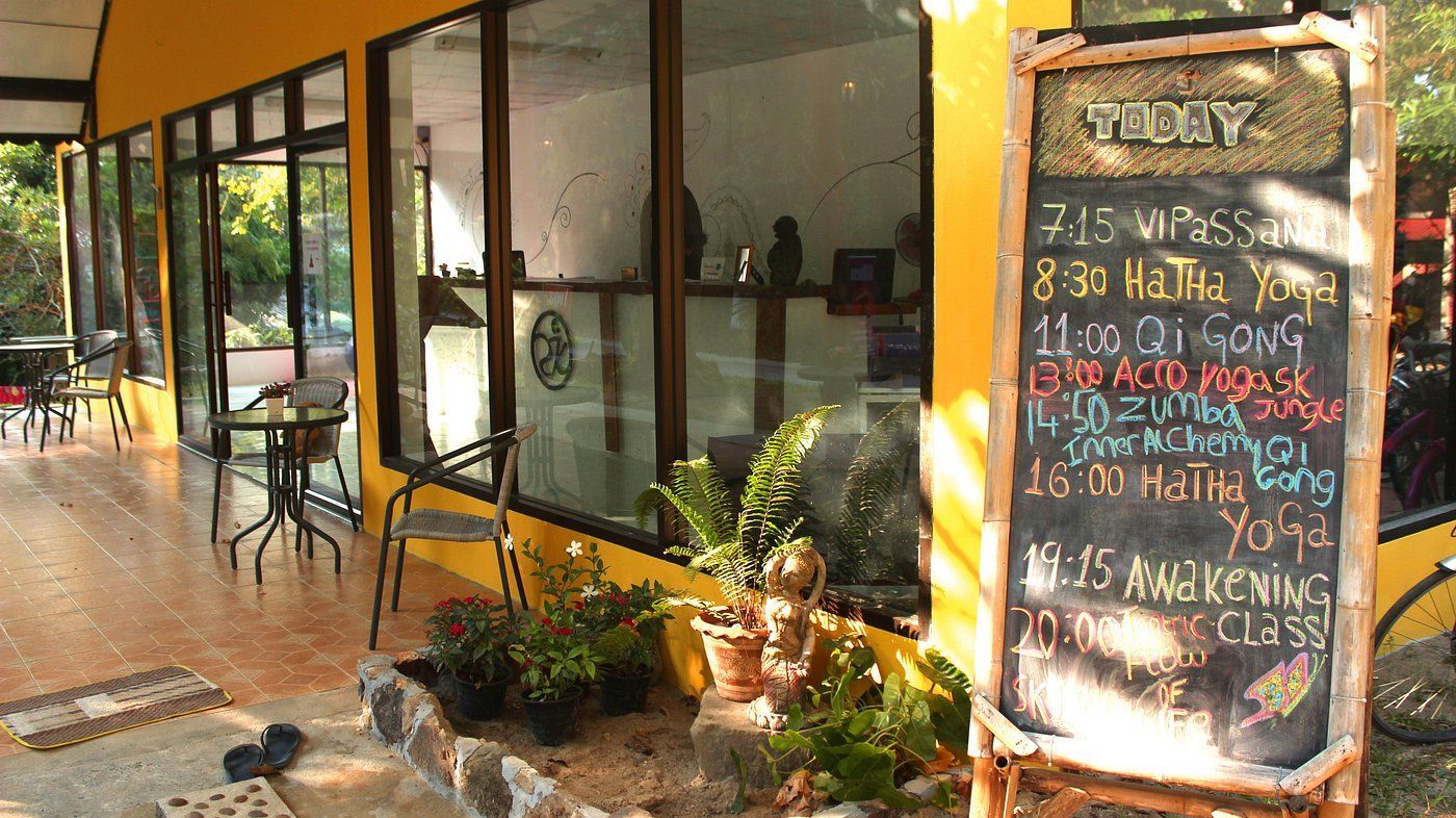 Outdoor café with glass windows and a chalkboard menu by the entrance.