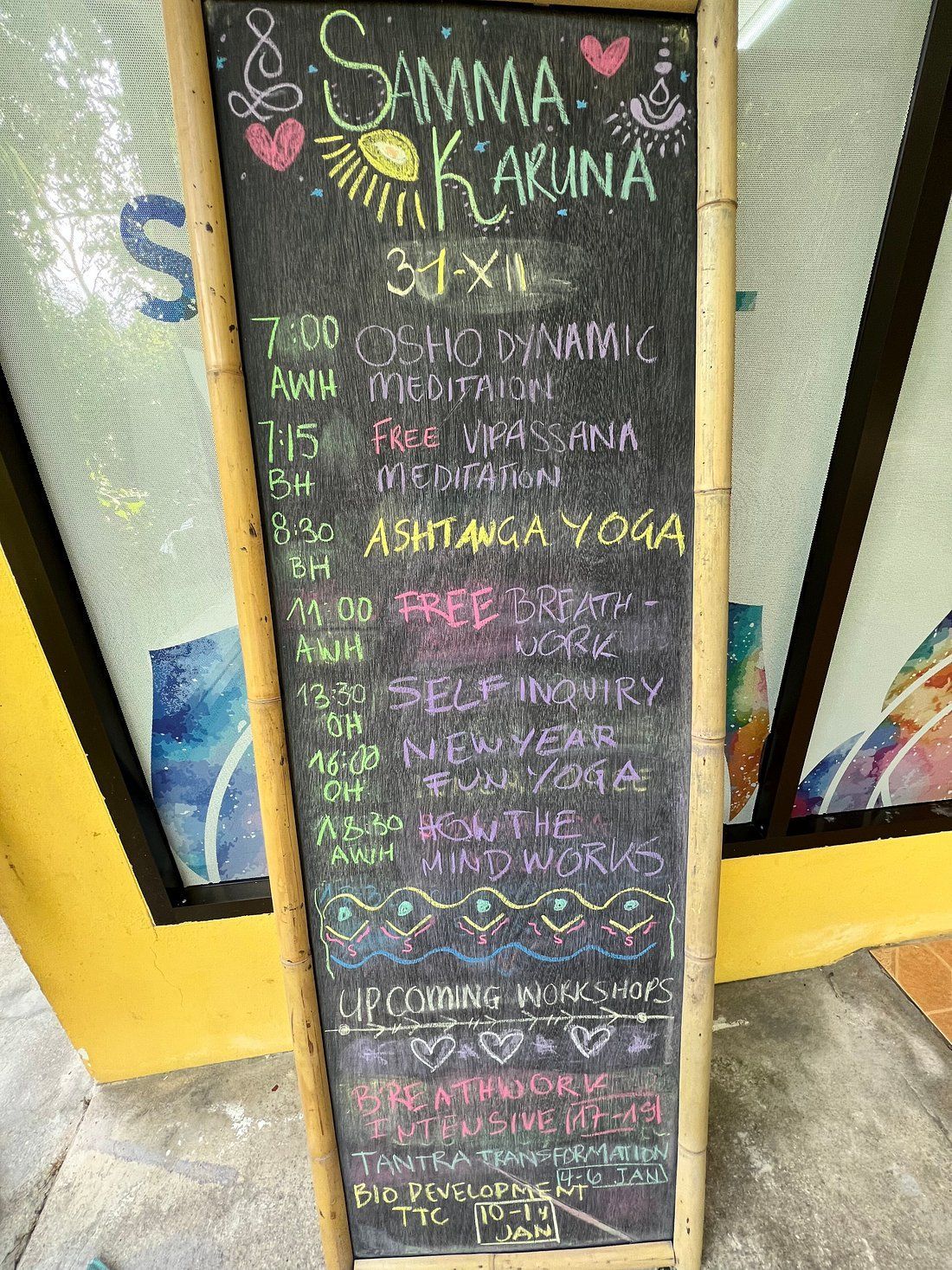 Chalkboard sign outside a yoga studio advertising classes in colorful handwritten chalk