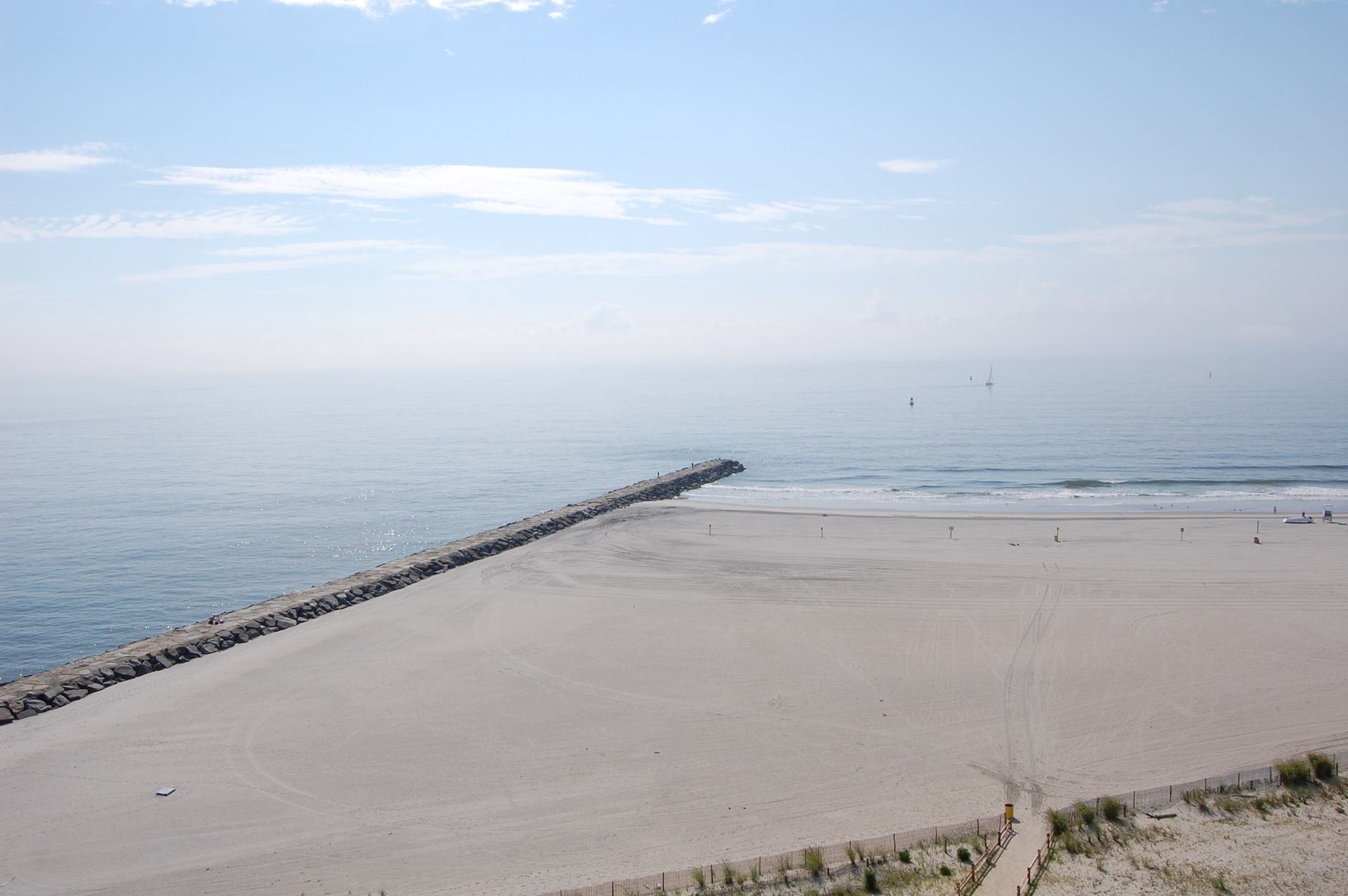 A beach with a pier and a body of water in the background.
