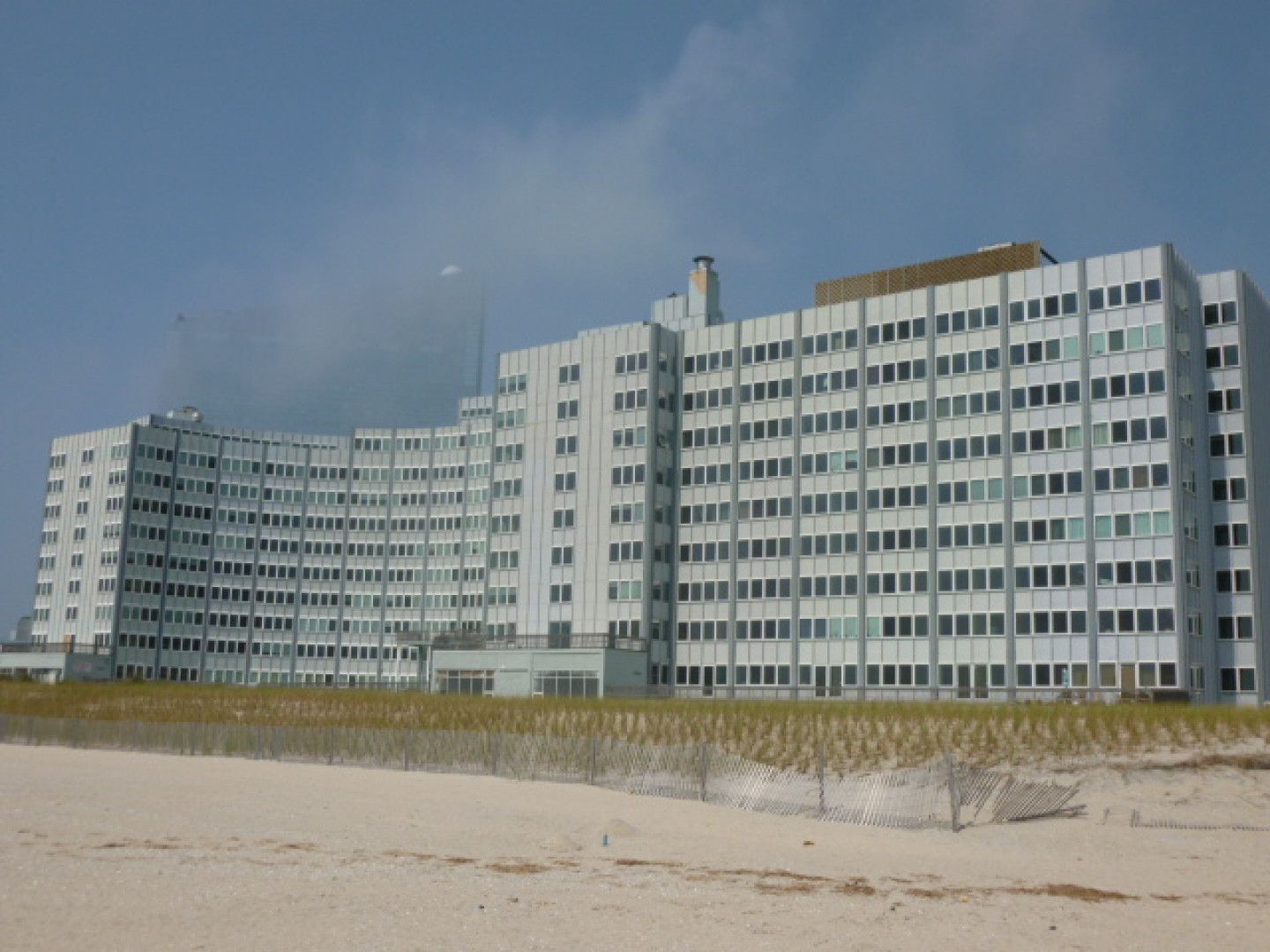 A large building is sitting on top of a sandy beach