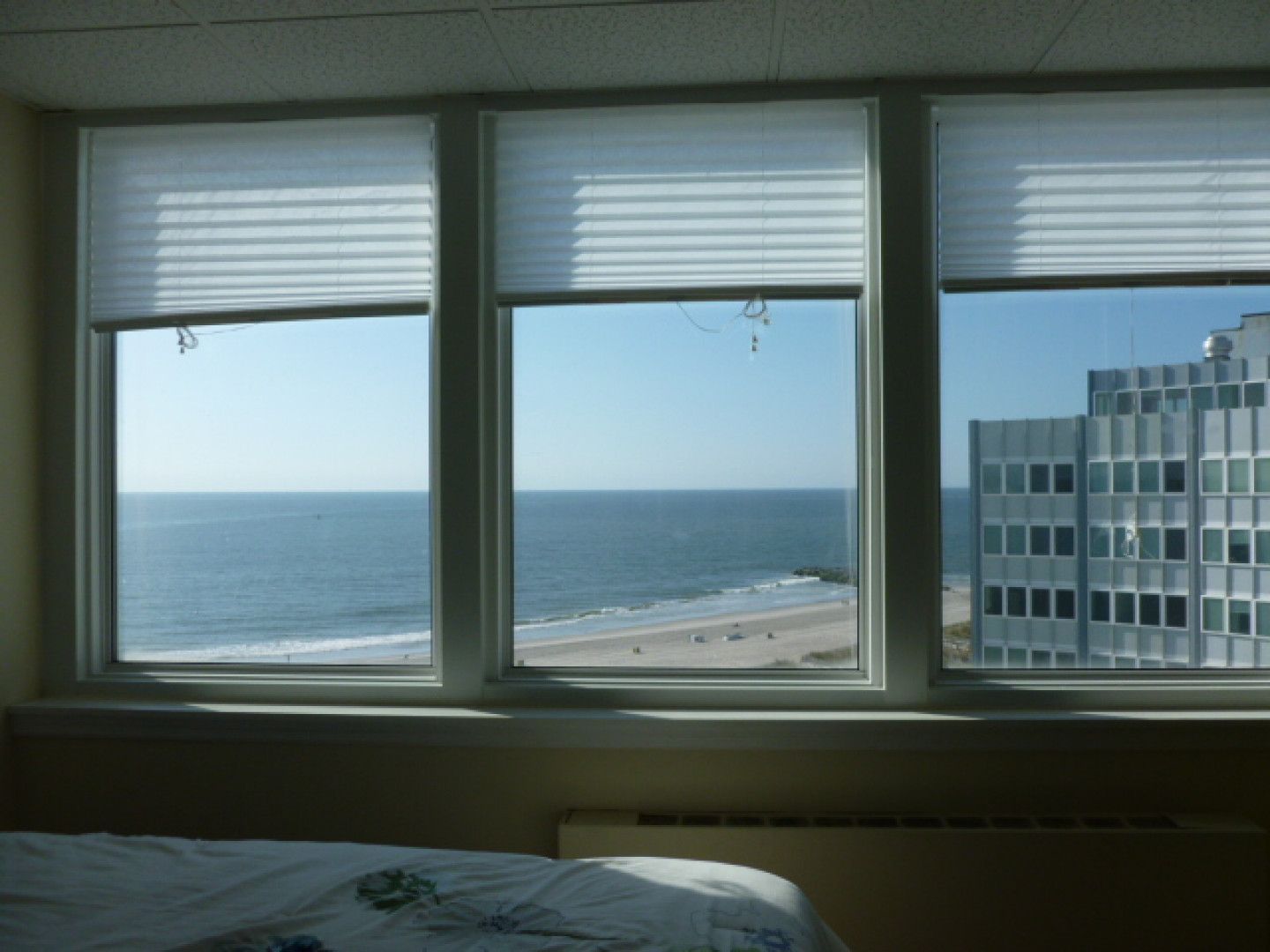 A bedroom with a view of the ocean and buildings