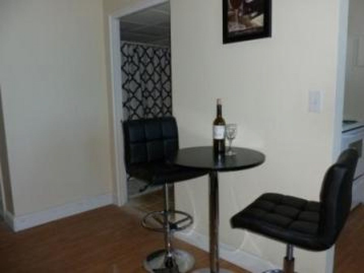 A small table with a bottle of wine and two glasses on it