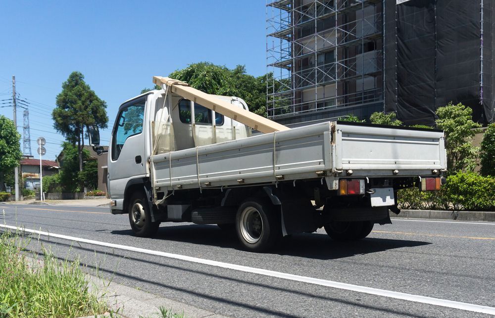White Flatbed Truck Carrying Lumber on a Road, Sunny Day — GC Custom Fabrication in Brisbane, QLD