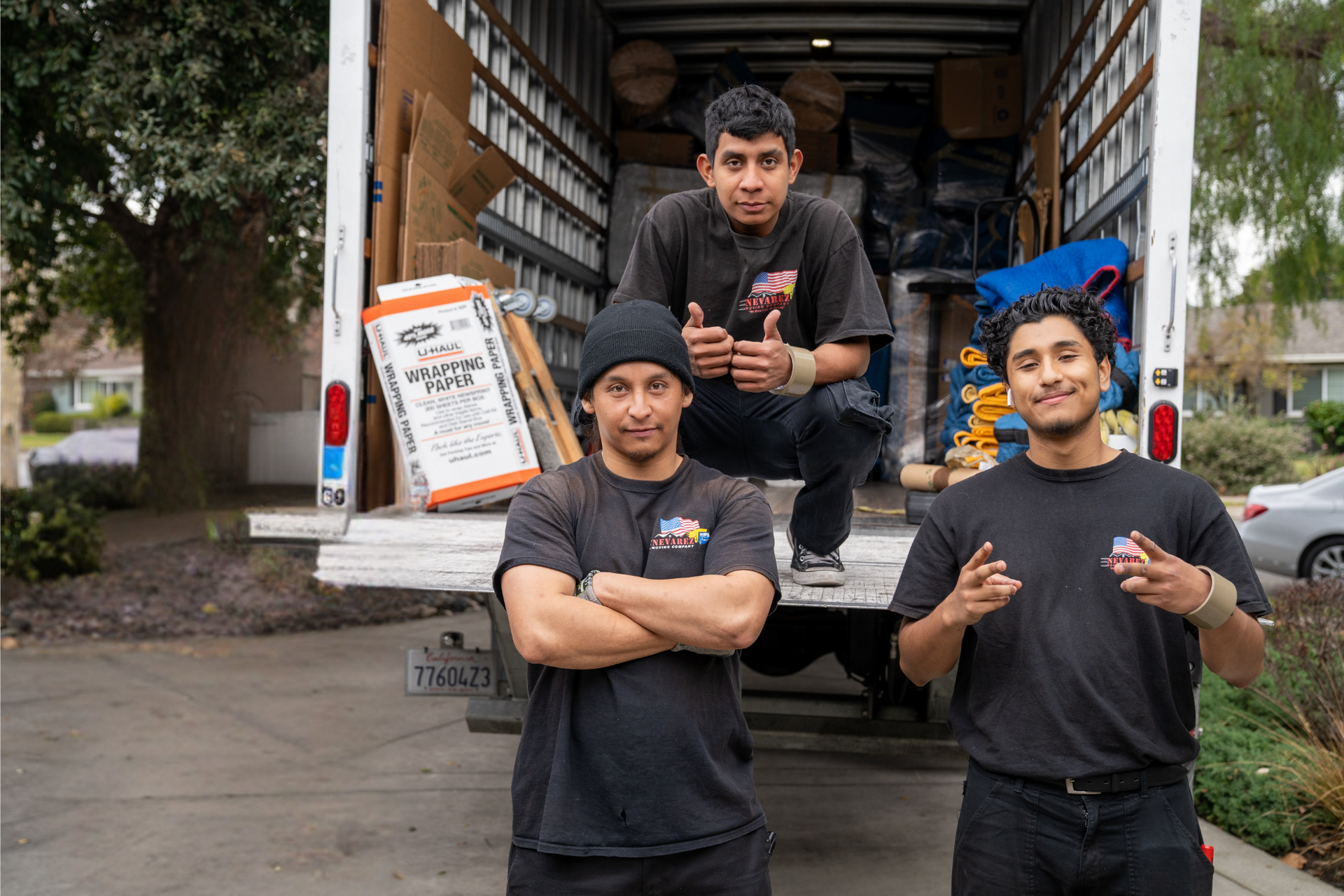 A group of men are standing in front of a moving truck.