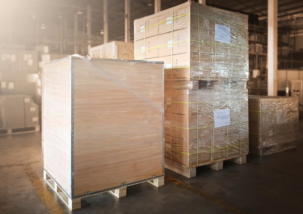A warehouse filled with lots of boxes on wooden pallets.