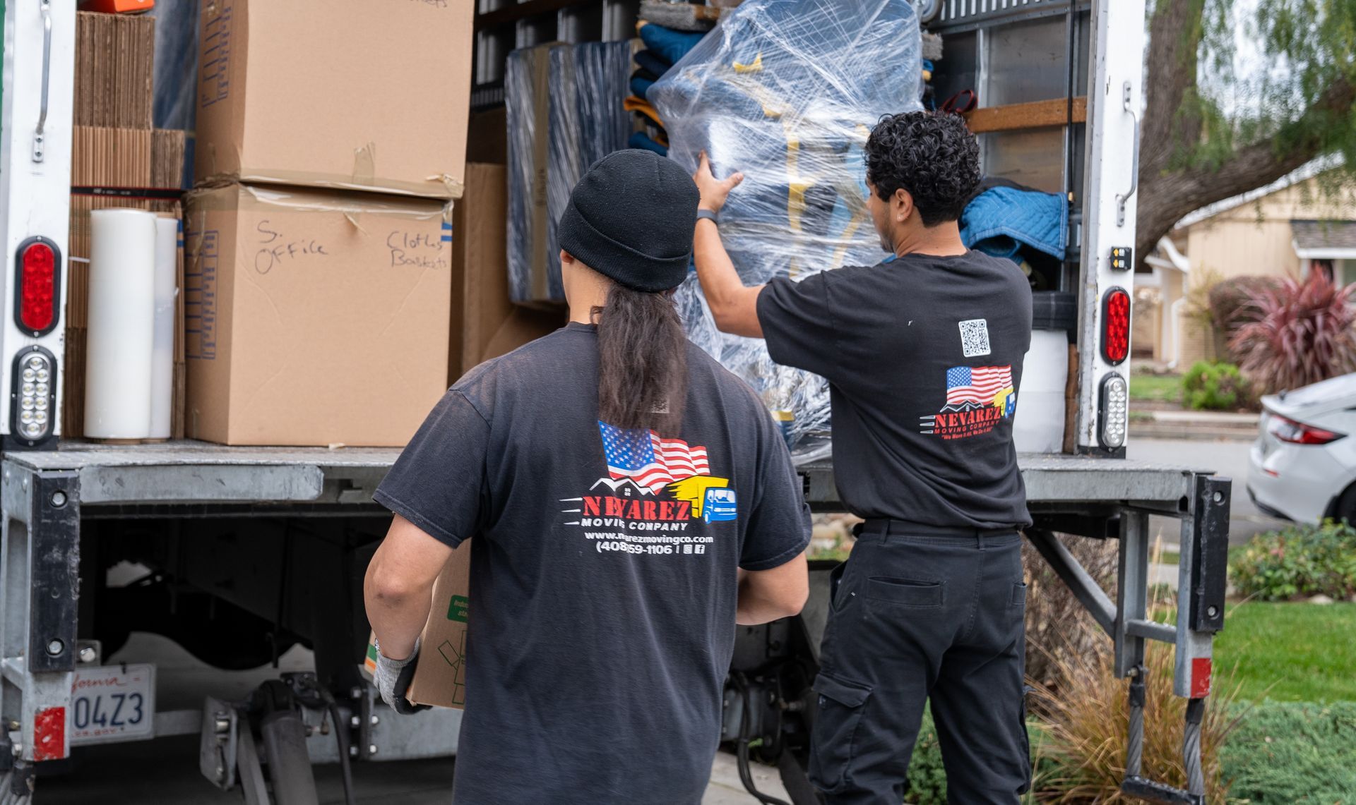 Two men are loading boxes into a moving truck.