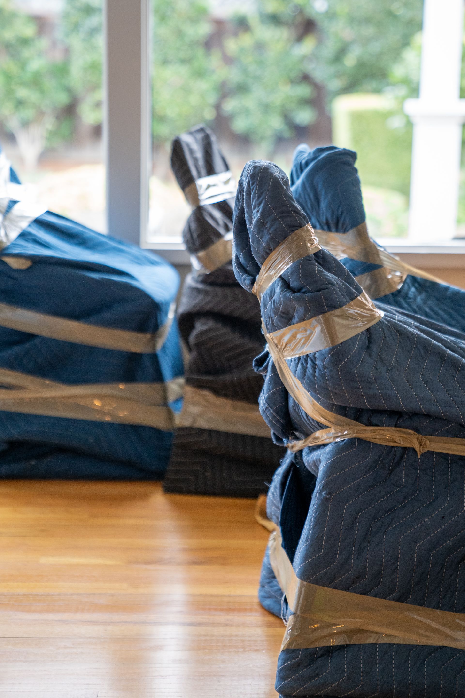 A stack of blue blankets wrapped in tape on a wooden table.