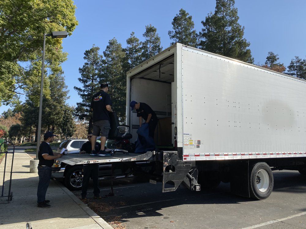 A group of men are loading a truck in a parking lot.