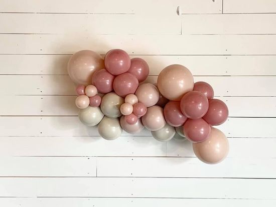 A bunch of pink and white balloons are hanging on a white wooden wall. A bunch of pink and white balloons are hanging on a white wooden wall.