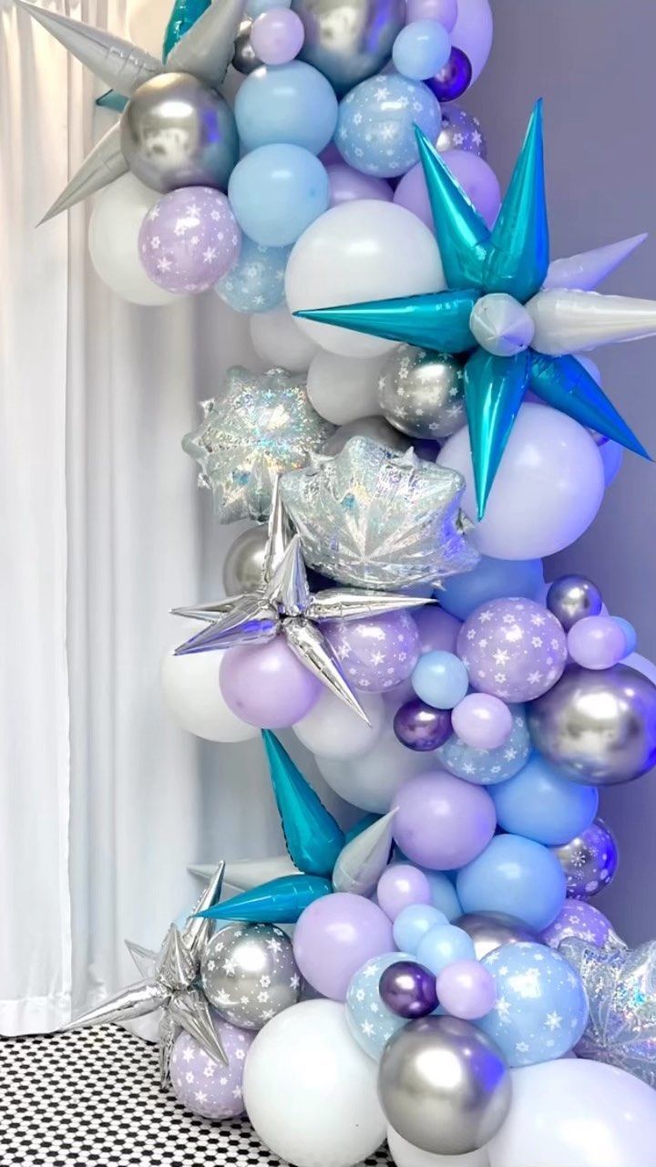 A bunch of balloons are stacked on top of each other in a room.