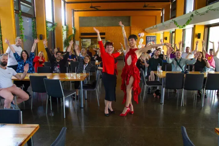 People celebrating at a event; two people in red outfits posing.