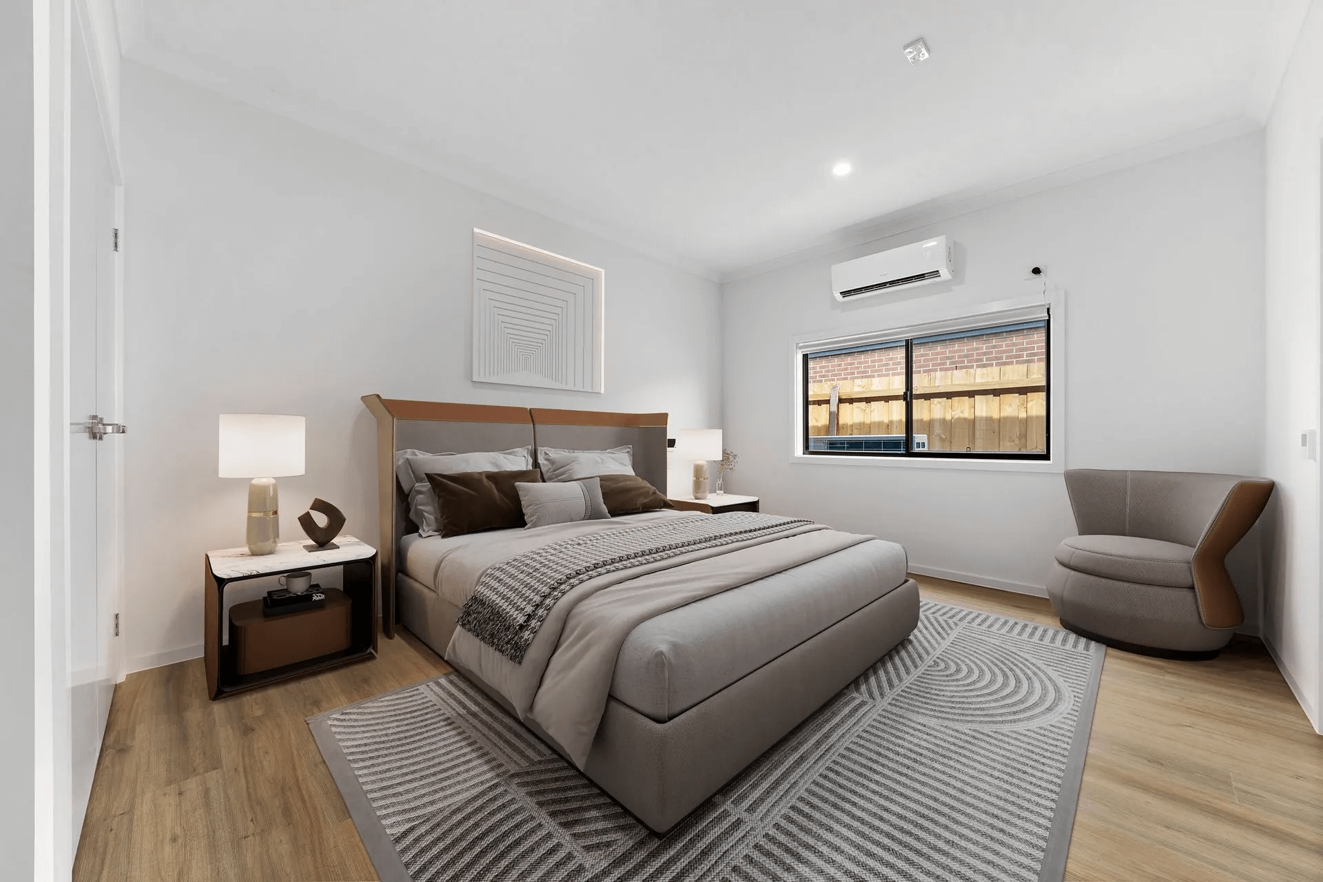 Bedroom with bed, nightstands, armchair, window, and rug. White walls, wooden floor, and neutral colors.