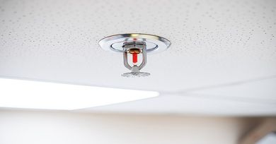 A fire sprinkler is hanging from the ceiling of a room.