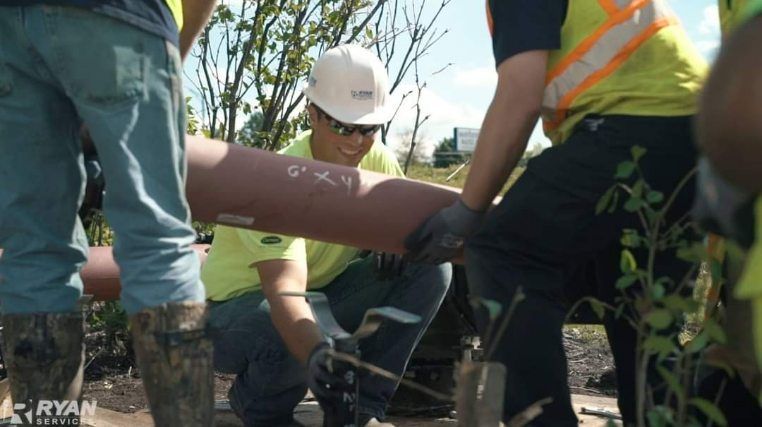 A group of construction workers are working on a pipe