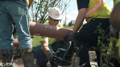 A group of construction workers are working on a pipe