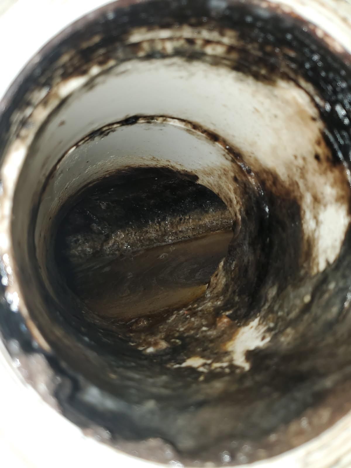 Inside of a dirty metal pipe with rust and grime buildup