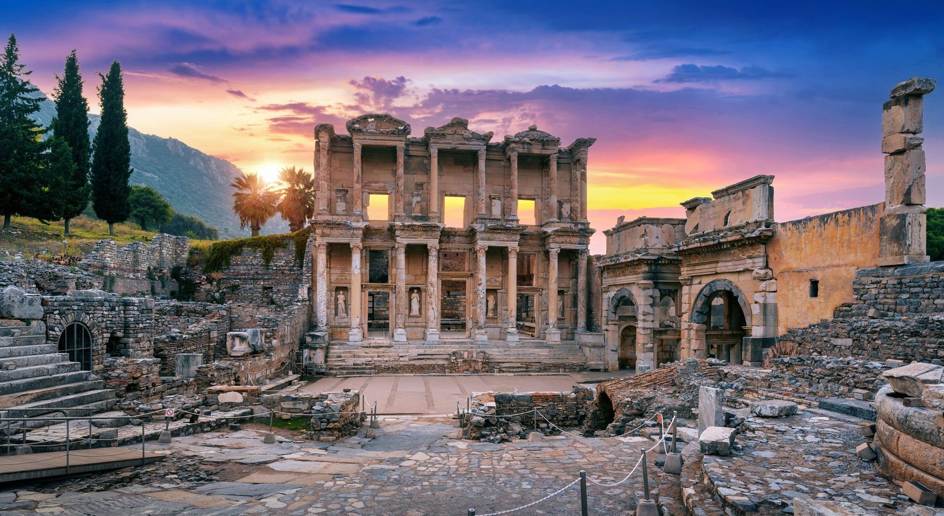 The Library of Celsus at Ephesus, Turkey, bathed in the golden, purple light of a sunset.