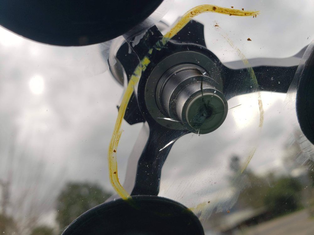 Close-up of a metal screw fastening a yellow measuring tape on a black suction cup mount