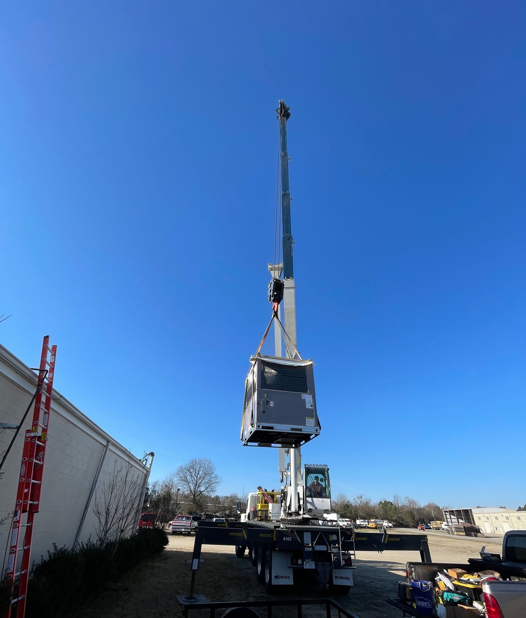 A large crane is sitting on top of a truck in a parking lot