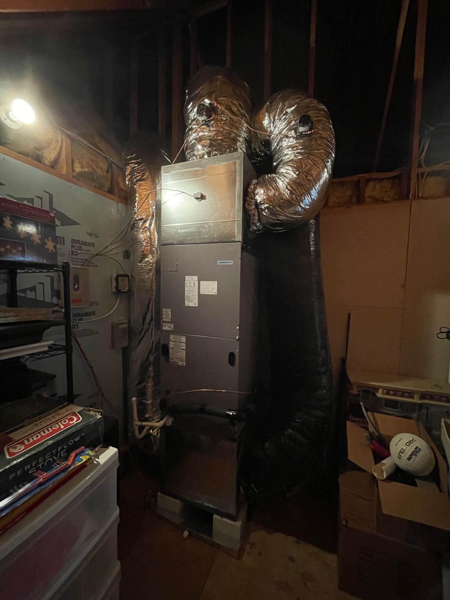 A room with a heater and a bunch of boxes on the floor.