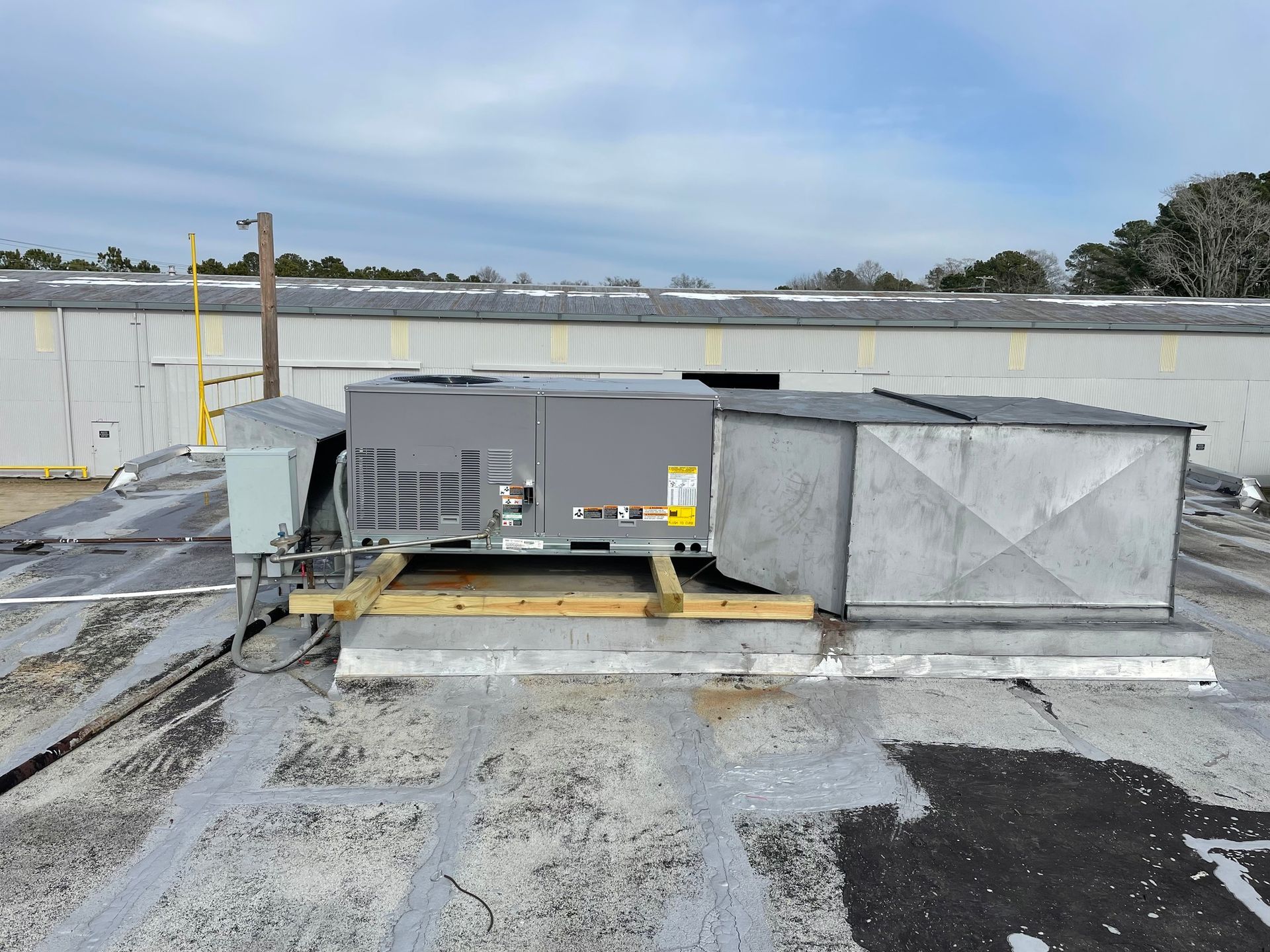 A large air conditioner is sitting on top of a roof.